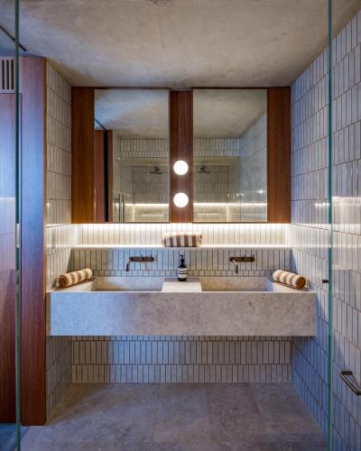 a bathroom with two sinks and a large mirror at Camperdown - Luxury Architectural Escape in Sydney