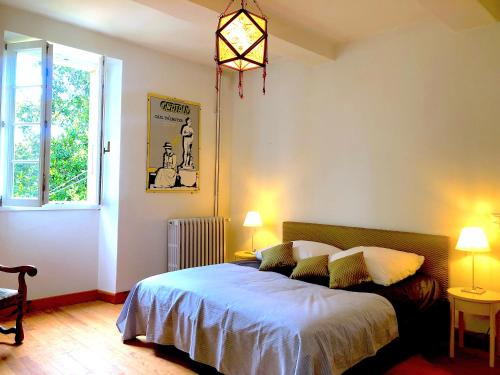 a bedroom with a bed and a window at Domaine Le Berdoy in Montesquiou