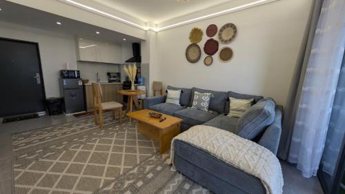 a living room with a blue couch and a table at Forest View - Lavington in Nairobi