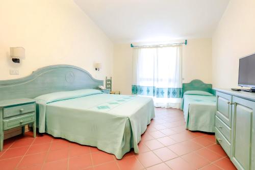 a bedroom with a large bed and a television at Hotiday Golfo Aranci in Golfo Aranci
