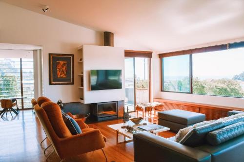 a living room with a couch and a tv at Just Like Home - Casa do Caracol Horizon Retreat in Viana do Castelo