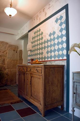 a kitchen with a wooden cabinet and a tile wall at O Quinteiro de Elvira in Moaña