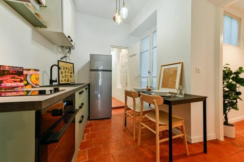 une cuisine avec une table et un réfrigérateur dans l'établissement Flora - Hypercentral City trip Cozy - by TGB, à Ajaccio