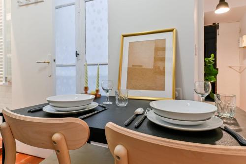 - une table à manger avec 2 assiettes et des verres blancs dans l'établissement Flora - Hypercentral City trip Cozy - by TGB, à Ajaccio