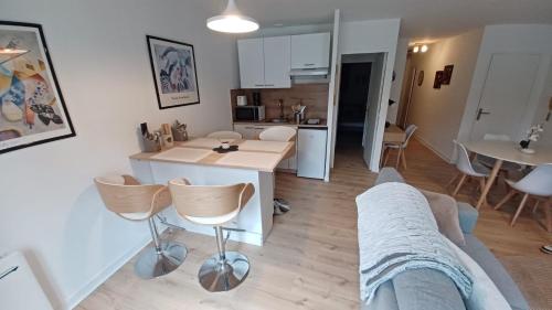 une cuisine et un salon avec une table et des chaises dans l'établissement Le Petit Cozy - T2 en centre-ville, à Poitiers