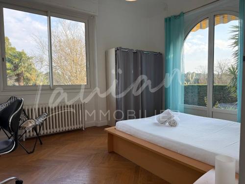 une chambre avec un lit et deux grandes fenêtres dans l'établissement Villa Coco - Prestations haut de gamme, à Arcangues