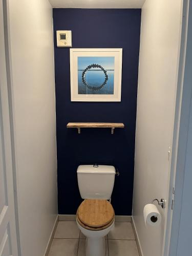 La salle de bains est pourvue de toilettes avec un mur bleu. dans l'établissement Appartement Vue Mer - Les Sables d'Olonne, à Les Sables-dʼOlonne