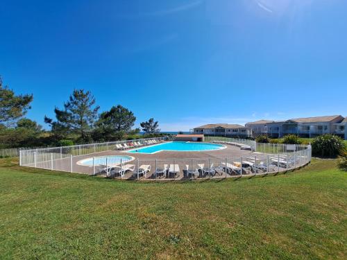 - une vue sur la piscine et ses chaises longues dans la cour dans l'établissement Appartement Vue Mer - Les Sables d'Olonne, à Les Sables-dʼOlonne