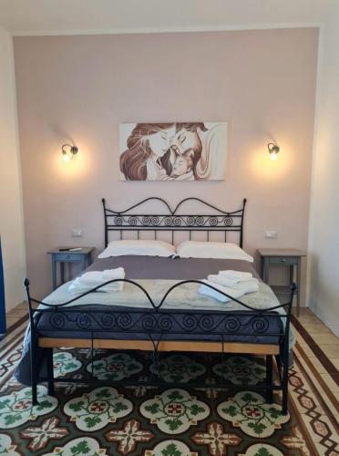 a bedroom with a black bed with a painting on the wall at Dimora Valicenti in San Giorgio Lucano