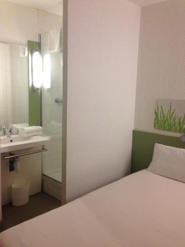 La salle de bains est pourvue d'un lit, d'un lavabo et d'une douche. dans l'établissement Ibis Budget Rambouillet, à Rambouillet