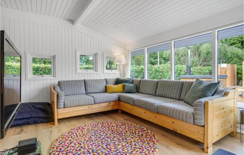 a couch in a living room with windows at Three-Bedroom Holiday Home In Ebeltoft in Ebeltoft