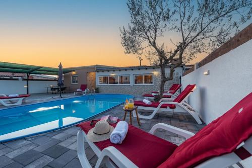 een villa met een zwembad en een patio bij Villa Luma ZadarVillas in Gorica