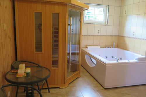 a bathroom with a washing machine and a table and a tub at Apartments Skiareál U Vodárny Bedřichov in Janov nad Nisou