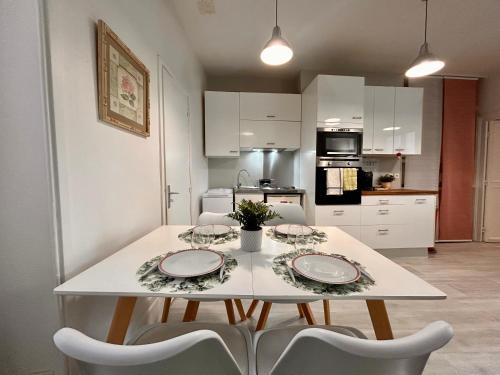 a white table with two plates on it in a kitchen at Rue piétonne - 4 pers - Proche place du marche in Fontainebleau