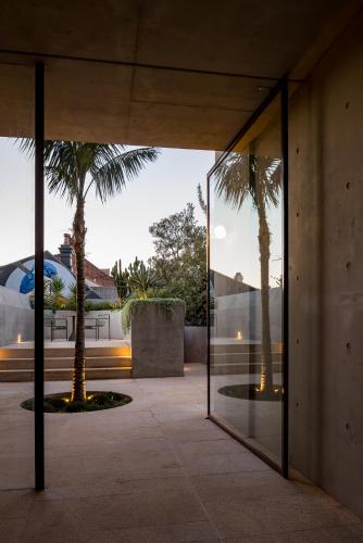 a building with glass doors with palm trees in the background at Camperdown- Luxury Architectural Apartment Escape in Sydney