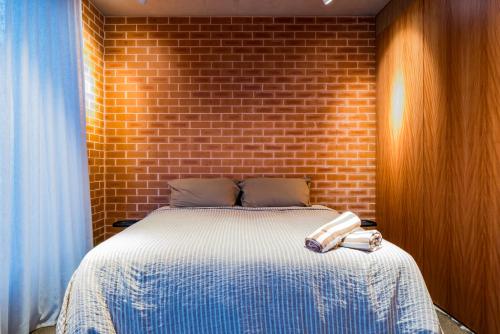 a bedroom with a bed with a brick wall at Camperdown- Luxury Architectural Apartment Escape in Sydney