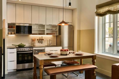 a kitchen with a wooden table with chairs and a tableasteryasteryasteryasteryastery at The Ann Savannah, Apartments by Marriott Bonvoy in Savannah
