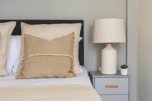 a bed with a pillow and a lamp on a nightstand at Appartement Spacieux à El Mouradia in El Mouradia