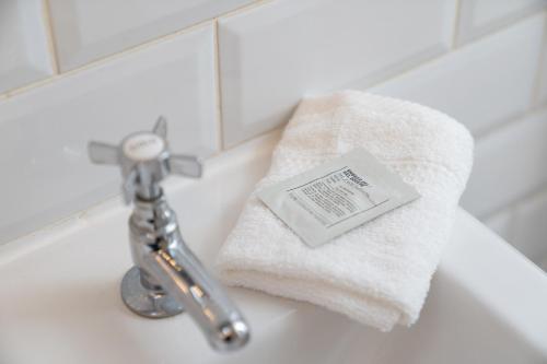 a towel sitting on top of a bathroom sink at Niru Experience Stylish Garden Getaway in London