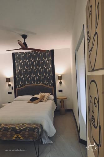 a bedroom with a large bed with a black headboard at Apartamentos Al-Karika in Coria
