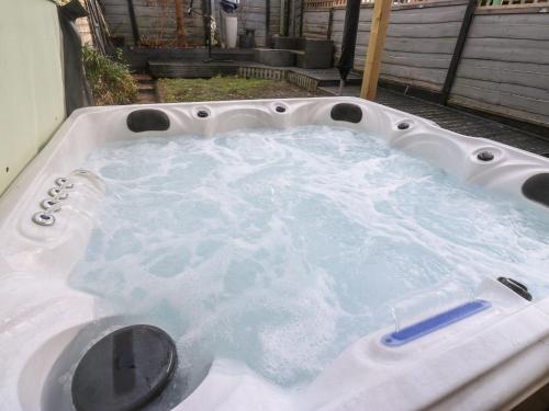 a jacuzzi tub filled with water in a backyard at Pickwood Grange in Sowerby Bridge