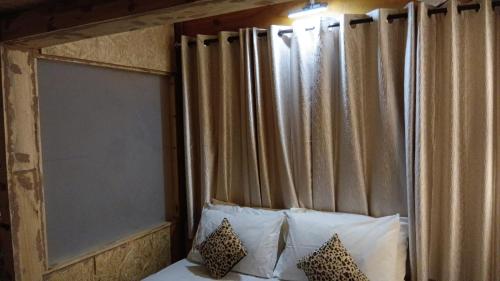 a bed with a wooden headboard with pillows at De Rock Jungle Living Resort in Coonoor