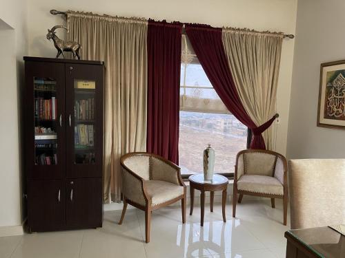 a living room with a table and chairs and a window at Scenic Cozy Retreat in Islamabad in Islamabad