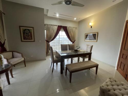 a dining room with a table and chairs and a window at Scenic Cozy Retreat in Islamabad in Islamabad
