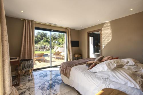 une chambre avec un lit et une porte coulissante en verre dans l'établissement La Villa Luxury Green patio, à Cirendinu