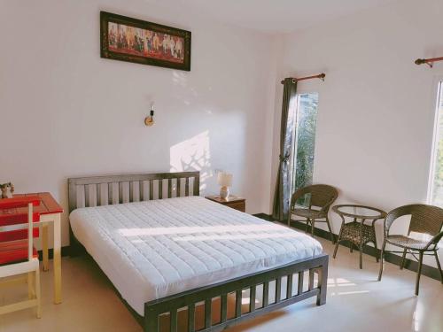 ホアヒンにあるBaan Mae Num HuaHin 102 บ้านแม่นุ่มのベッドとテーブルと椅子のある寝室