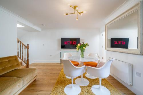 a dining room with a table and chairs at Niru Experience Stylish Garden Getaway in London