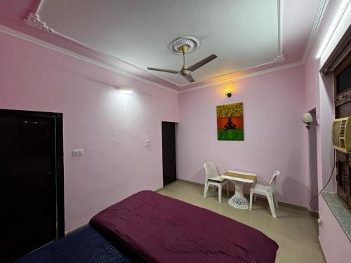 a bedroom with a bed and a table with chairs at Vedic Stays Haridwar in Haridwār