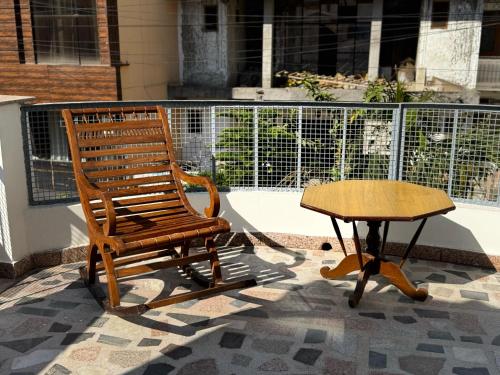 a rocking chair and a table on a patio at Vedic Stays Haridwar in Haridwār