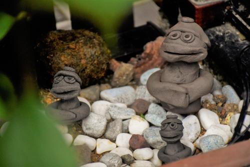 a group of three stone statues sitting on rocks at Guest House Oumi in Kyoto