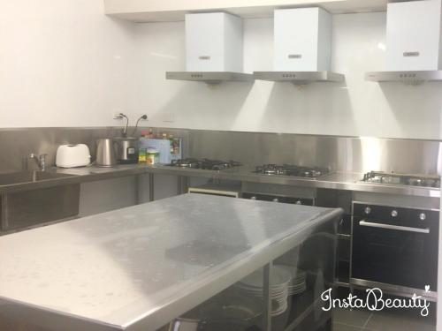 a kitchen with stainless steel counter tops and appliances at Five 2 Home Backpacker in Brisbane