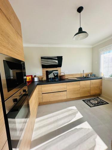 une cuisine avec un évier et un micro-ondes dans l'établissement Maison chaleureuse vue cité, à Carcassonne