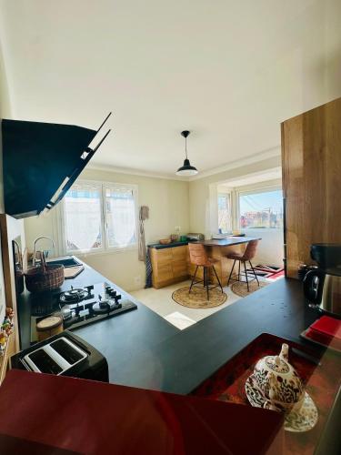 une cuisine avec une cuisinière et une table à l'intérieur dans l'établissement Maison chaleureuse vue cité, à Carcassonne