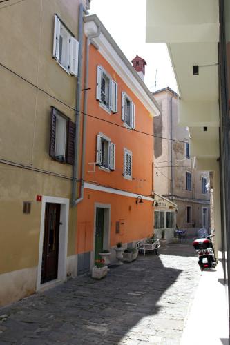 an alley with orange buildings and a scooter on a street at Bed and Brekfast Donatella in Piran