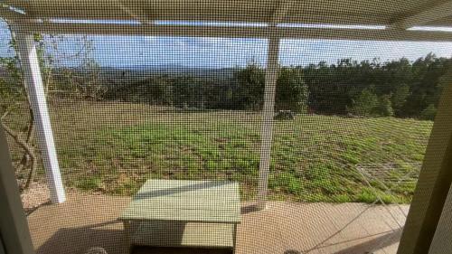 a screened in porch with a view of a yard at Vale das Estrelas in São Teotónio
