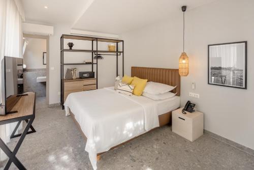 Un dormitorio con una gran cama blanca y un escritorio. en Waterman Svpetrvs Resort - All Inclusive, en Supetar