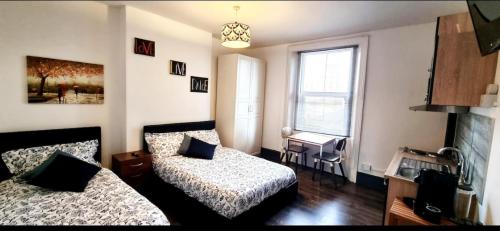 a small bedroom with two beds and a window at Studio Flat in Vauxhall Zone 1 in London