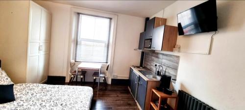 a small room with a bed and a kitchen with a sink at Studio Flat in Vauxhall Zone 1 in London