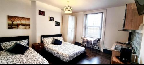 a small bedroom with two beds and a window at Studio Flat in Vauxhall Zone 1 in London