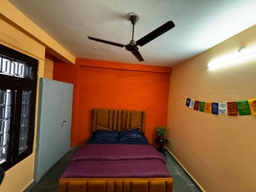 a bedroom with a bed with a ceiling fan at Vedic Stays Haridwar in Haridwār