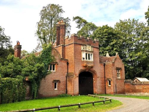an old red brick building with a large door at North Lodge North in Knebworth
