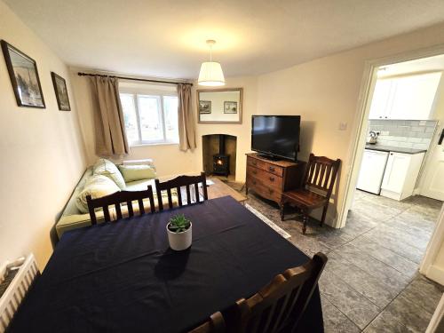 a living room with a table and a couch and a television at North Lodge North in Knebworth