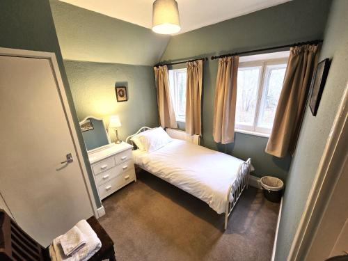 a small bedroom with a bed and a window at North Lodge North in Knebworth