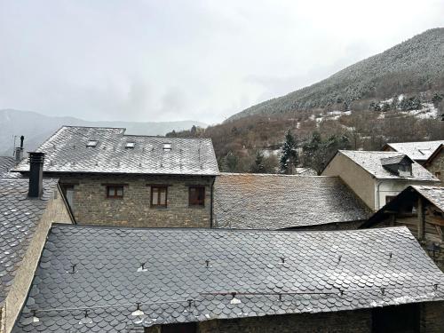 a group of buildings with mountains in the background at Dúplex amb encant al centre d'Espot by RURAL D'ÀNEU in Espot