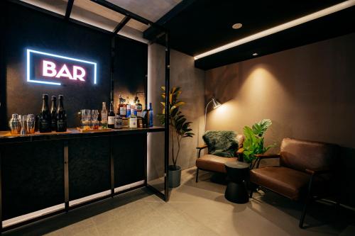 a bar with a chair and a bar sign on the wall at Hotel The Loop in Tokyo