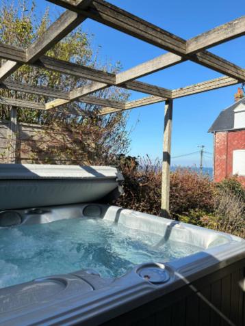 a hot tub in a backyard with a wooden roof at Villa La Smalah, familiale 6 chambres- vue Mer - jacuzzi - wifi - tout confort in Ault